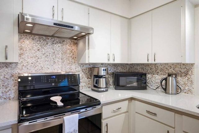 4731 Egret Rd, Venice, FL 34293 - kitchen with under cabinet range hood, white cabinetry, black microwave, backsplash, and electric range