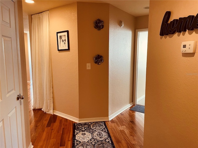 hall featuring baseboards and wood finished floors