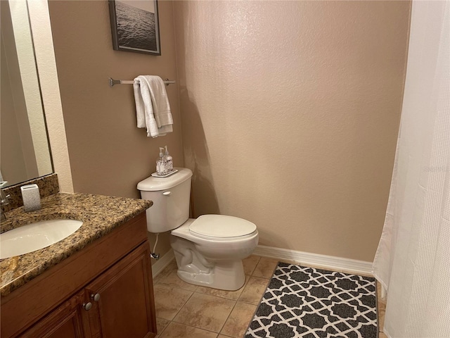 bathroom with tile patterned flooring, toilet, vanity, and baseboards