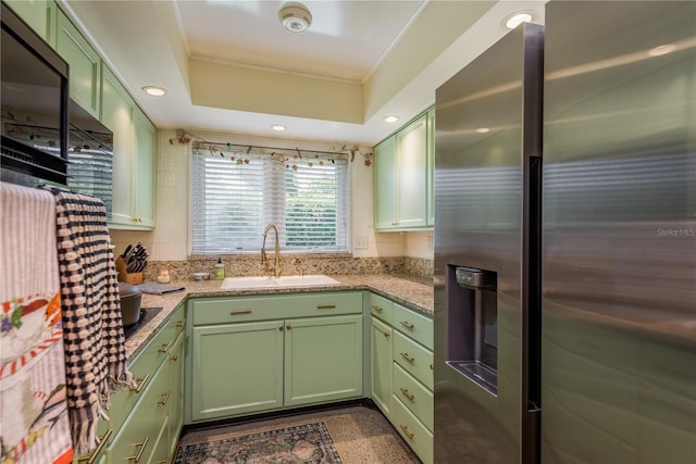 kitchen featuring stainless steel fridge with ice dispenser, green cabinetry, and a sink