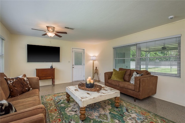 living area with baseboards, a textured ceiling, a ceiling fan, visible vents, and speckled floor