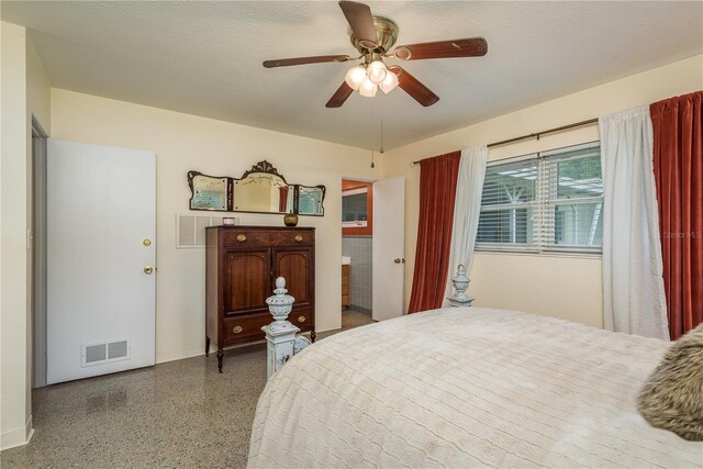bedroom featuring visible vents, a textured ceiling, speckled floor, and a ceiling fan