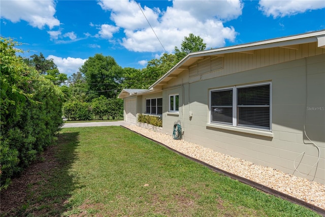 view of yard with a garage and concrete driveway