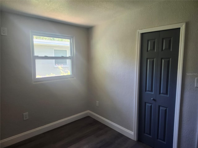 825 Lincoln Ave, Tarpon Springs, FL 34689 - interior space with a closet, a textured ceiling, baseboards, and dark wood-style flooring