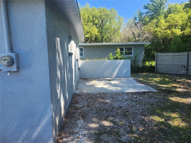 825 Lincoln Ave, Tarpon Springs, FL 34689 - view of home's exterior featuring stucco siding, fence, and a patio