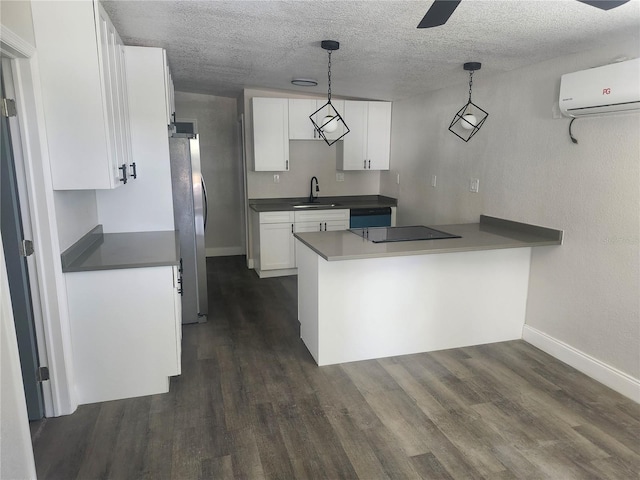 825 Lincoln Ave, Tarpon Springs, FL 34689 - kitchen with a wall mounted air conditioner, a sink, white cabinets, a peninsula, and freestanding refrigerator