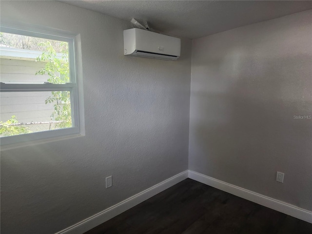 825 Lincoln Ave, Tarpon Springs, FL 34689 - spare room with a wall mounted air conditioner, a healthy amount of sunlight, baseboards, and dark wood-style floors