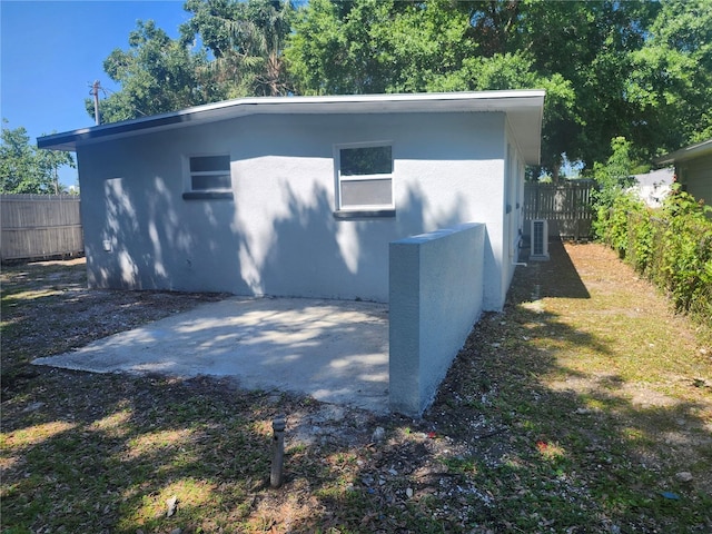 825 Lincoln Ave, Tarpon Springs, FL 34689 - exterior space with stucco siding, cooling unit, a patio, and a fenced backyard