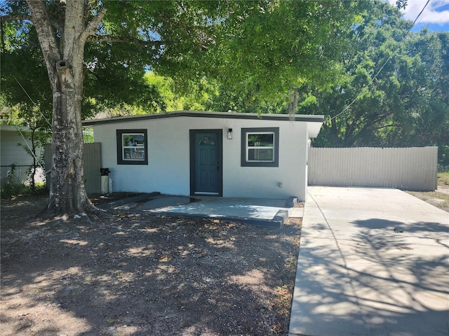 825 Lincoln Ave, Tarpon Springs, FL 34689 - view of front facade with fence and stucco siding