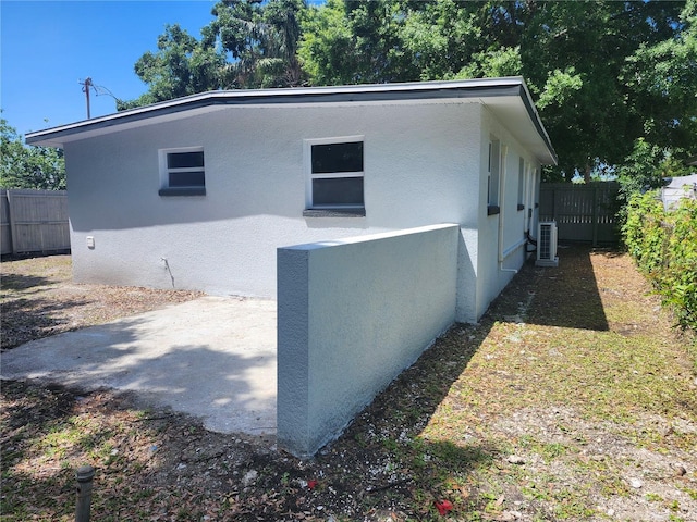 825 Lincoln Ave, Tarpon Springs, FL 34689 - view of property exterior with a patio, fence private yard, central AC unit, and stucco siding