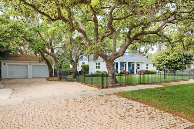 view of front of property with a front yard, decorative driveway, a garage, and a fenced front yard
