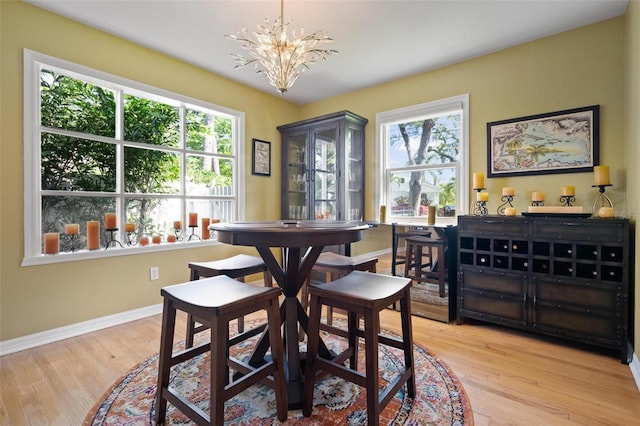 dining room with baseboards, an inviting chandelier, and wood finished floors
