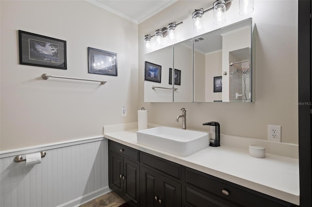 full bathroom featuring vanity, visible vents, crown molding, and wainscoting
