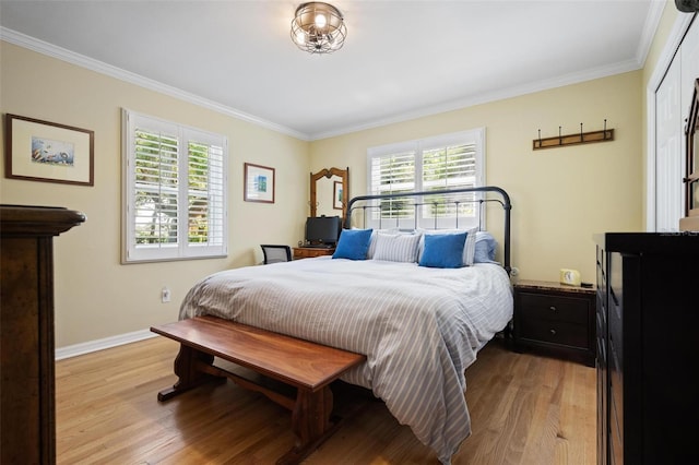 bedroom with baseboards, multiple windows, crown molding, and wood finished floors