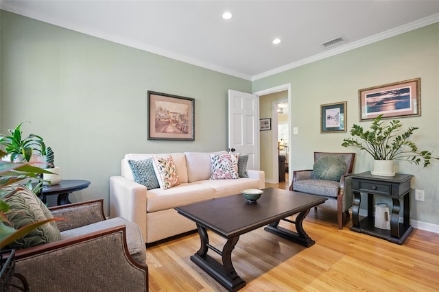 living room with baseboards, recessed lighting, crown molding, visible vents, and light wood finished floors