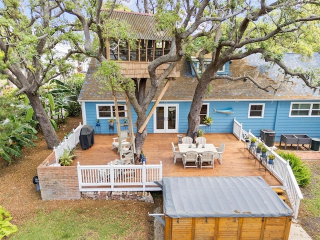 back of property with central AC unit, a deck, fence, outdoor dining area, and french doors