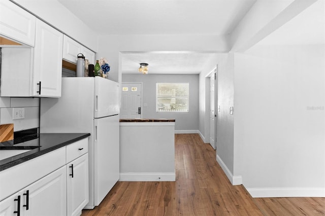 1309 45th St S, Saint Petersburg, FL 33711 - kitchen featuring white cabinets, baseboards, freestanding refrigerator, dark countertops, and wood finished floors