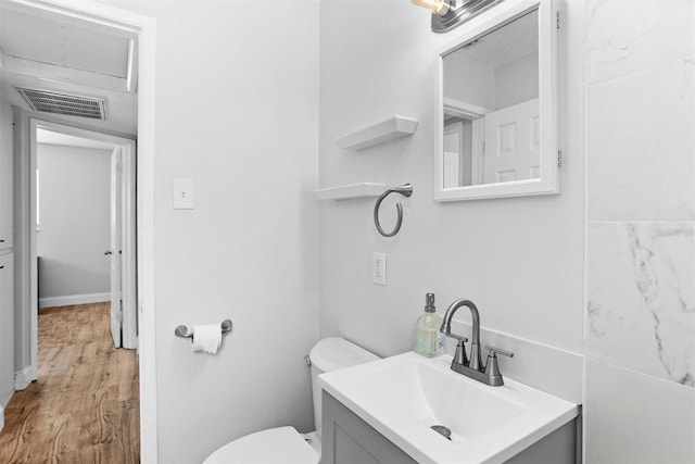 1309 45th St S, Saint Petersburg, FL 33711 - half bath with visible vents, toilet, vanity, and wood finished floors
