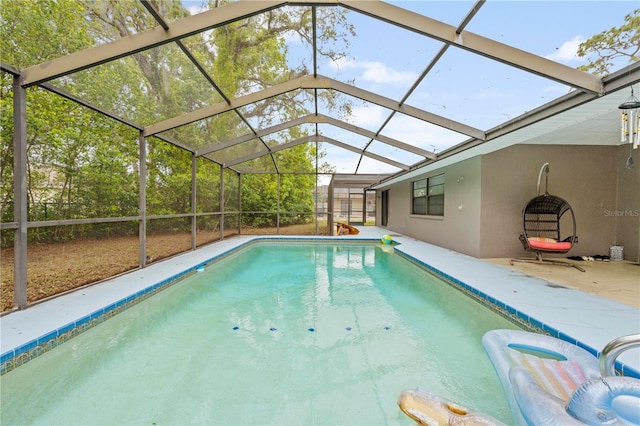 outdoor pool featuring a patio area and glass enclosure