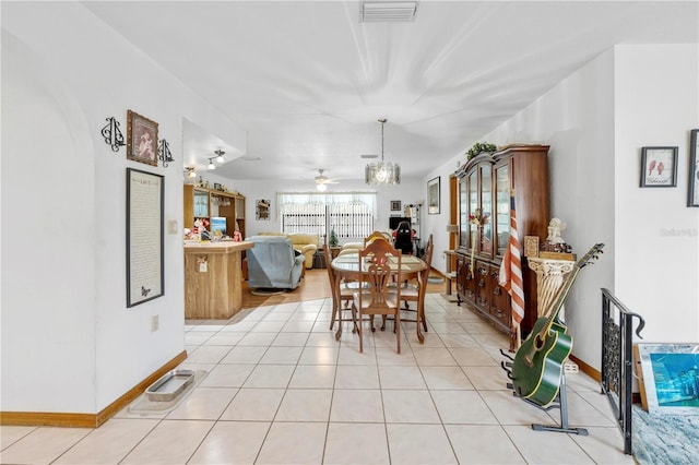 dining space featuring light tile patterned floors, baseboards, a ceiling fan, and visible vents