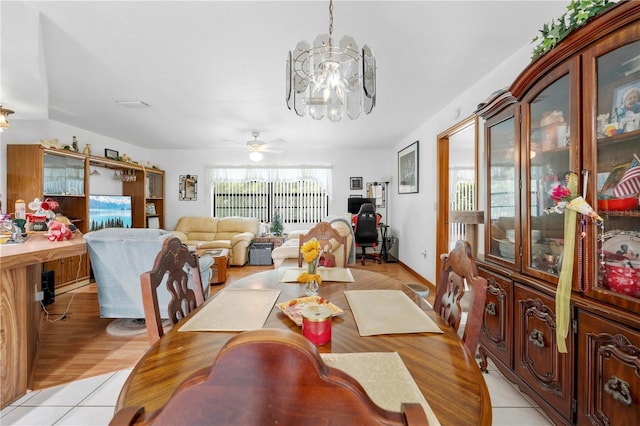 dining space featuring light tile patterned floors and ceiling fan with notable chandelier