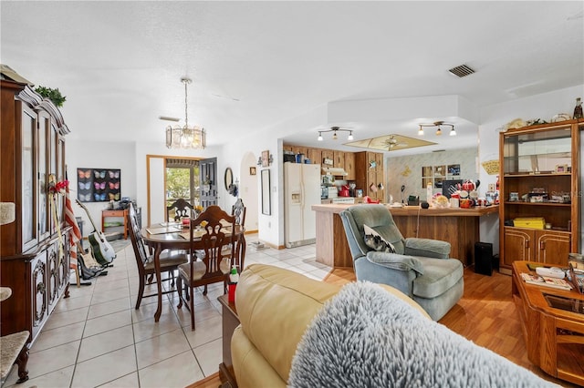 living area featuring a notable chandelier, visible vents, and light tile patterned flooring