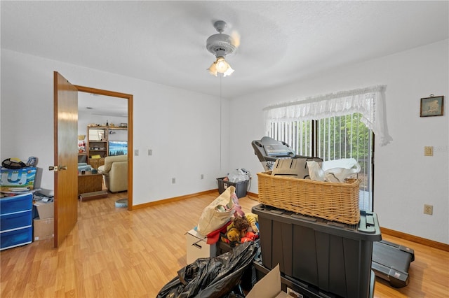 miscellaneous room with baseboards, a ceiling fan, and wood finished floors
