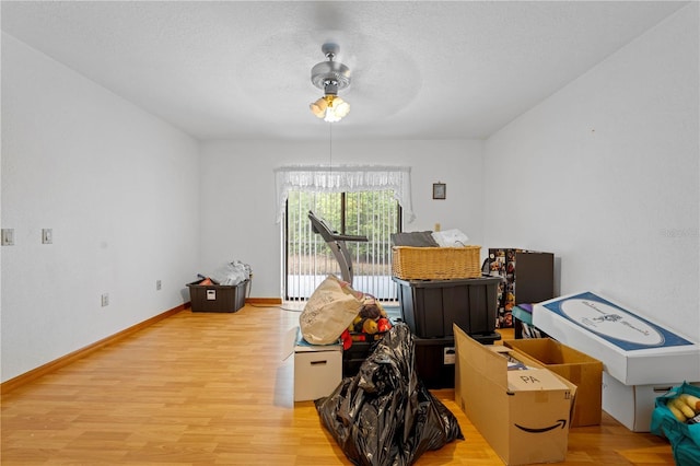 interior space with wood finished floors, baseboards, and a ceiling fan