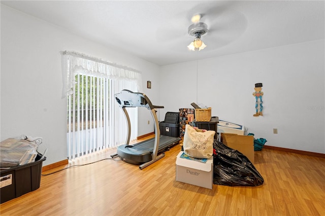workout area featuring ceiling fan, baseboards, and wood finished floors