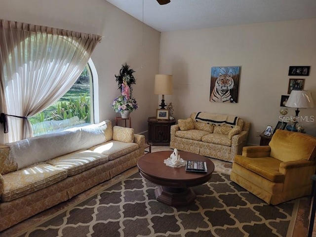 living area featuring a ceiling fan and lofted ceiling