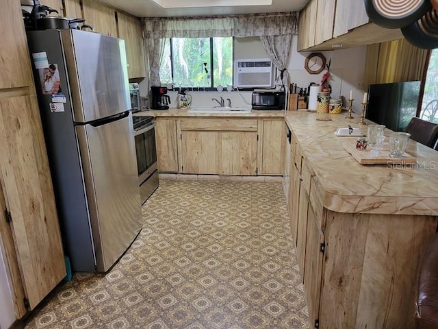 kitchen with light countertops, plenty of natural light, stainless steel appliances, and light brown cabinets