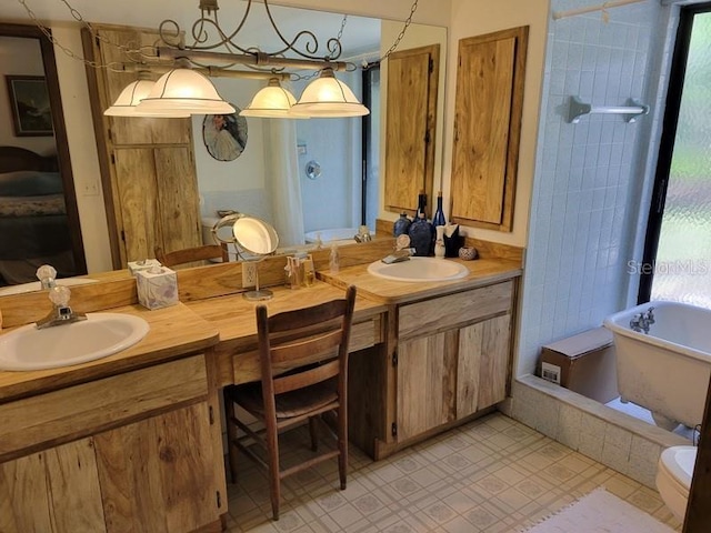 full bathroom featuring a sink, double vanity, and a freestanding bath