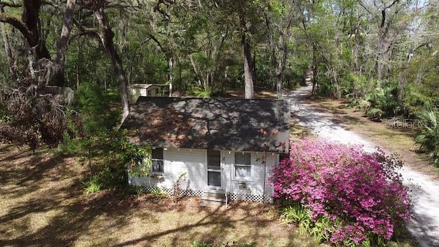 view of property hidden behind natural elements with a wooded view