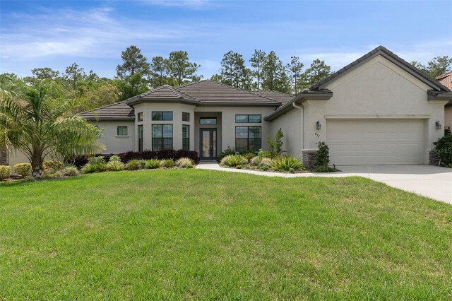 877 N Hunt Club Dr, Hernando, FL 34442 - view of front of house featuring an attached garage, driveway, a front lawn, and a tile roof
