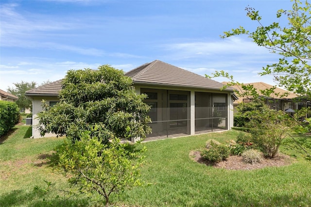 877 N Hunt Club Dr, Hernando, FL 34442 - back of property with a sunroom, a tiled roof, stucco siding, and a lawn