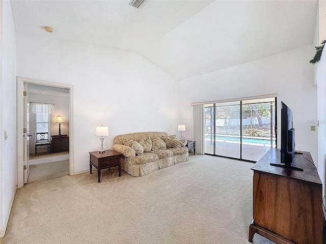 living room with a wealth of natural light, high vaulted ceiling, and light carpet