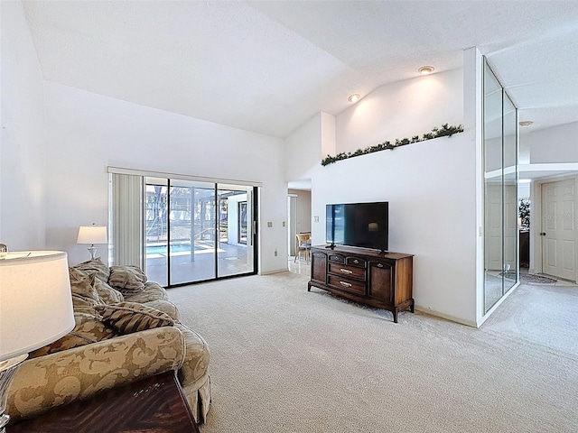 carpeted living room featuring baseboards and high vaulted ceiling