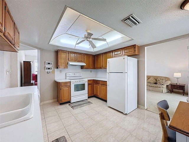 kitchen featuring a ceiling fan, brown cabinets, white appliances, under cabinet range hood, and visible vents