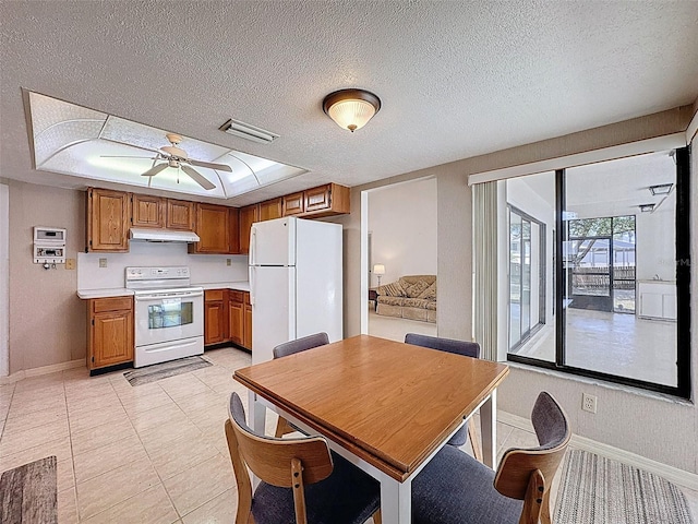 kitchen with baseboards, white appliances, brown cabinetry, light countertops, and under cabinet range hood