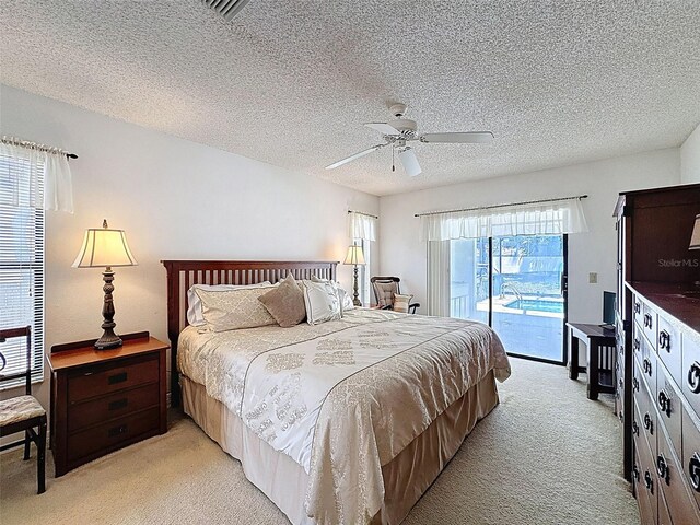 bedroom featuring visible vents, a textured ceiling, access to outside, light colored carpet, and ceiling fan