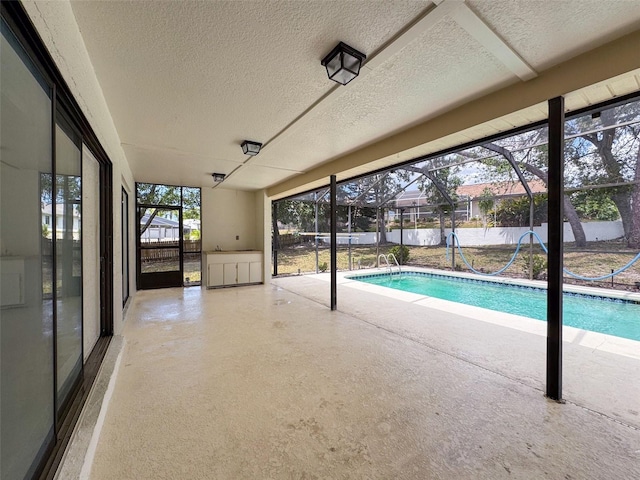 view of swimming pool featuring glass enclosure, a patio, and a fenced in pool