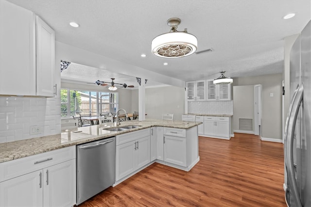 155 Patty Ann Blvd, Palm Harbor, FL 34683 - kitchen featuring white cabinetry, a ceiling fan, light wood-style floors, stainless steel appliances, and a sink