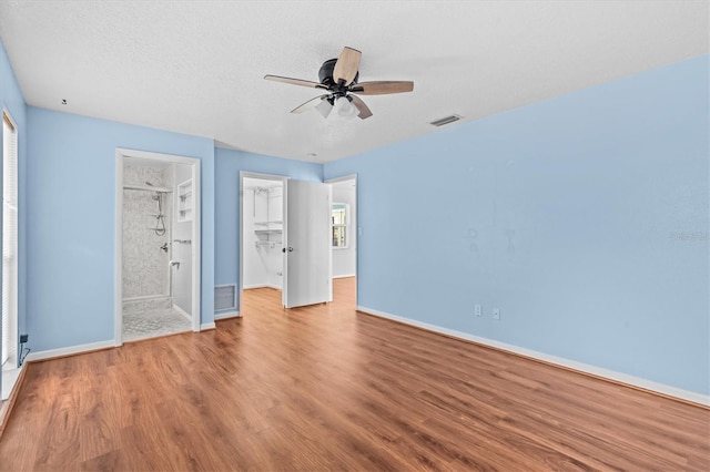 155 Patty Ann Blvd, Palm Harbor, FL 34683 - unfurnished bedroom featuring visible vents, baseboards, a spacious closet, a textured ceiling, and wood finished floors