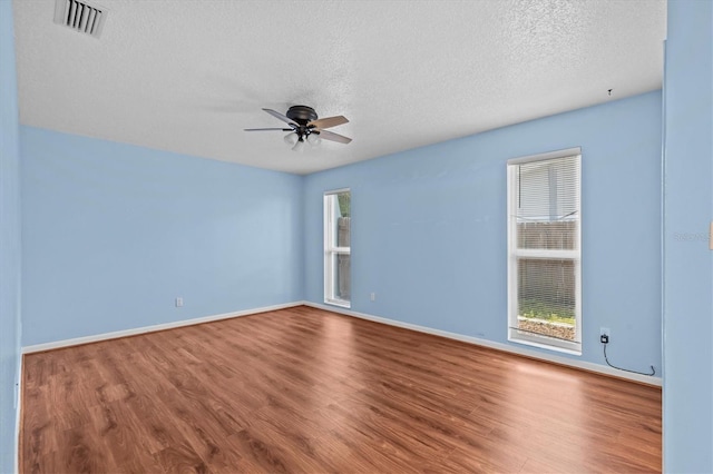 155 Patty Ann Blvd, Palm Harbor, FL 34683 - empty room with visible vents, a textured ceiling, a ceiling fan, and wood finished floors