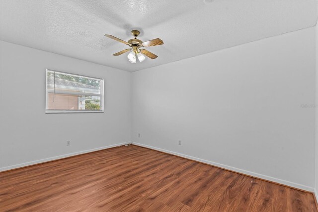 155 Patty Ann Blvd, Palm Harbor, FL 34683 - unfurnished room with ceiling fan, a textured ceiling, baseboards, and wood finished floors