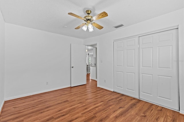155 Patty Ann Blvd, Palm Harbor, FL 34683 - unfurnished bedroom featuring a closet, baseboards, visible vents, ceiling fan, and wood finished floors