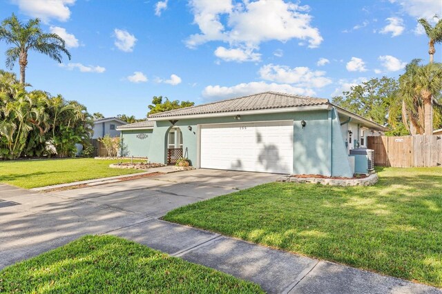 155 Patty Ann Blvd, Palm Harbor, FL 34683 - ranch-style home with a garage, a tile roof, fence, stucco siding, and driveway
