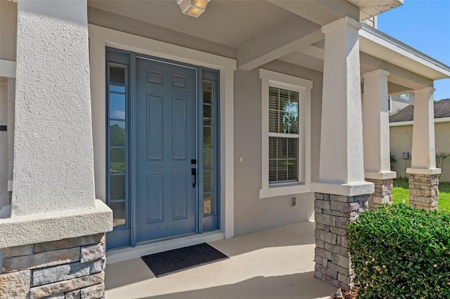 13619 Hunters Point St, Spring Hill, FL 34609 - entrance to property featuring covered porch, stucco siding, and stone siding