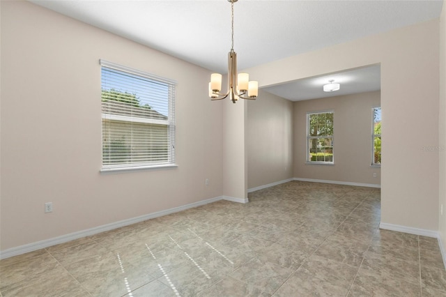 13619 Hunters Point St, Spring Hill, FL 34609 - empty room with a chandelier, plenty of natural light, and baseboards