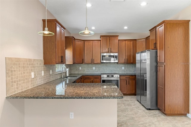 13619 Hunters Point St, Spring Hill, FL 34609 - kitchen with dark stone counters, a peninsula, appliances with stainless steel finishes, a sink, and brown cabinets